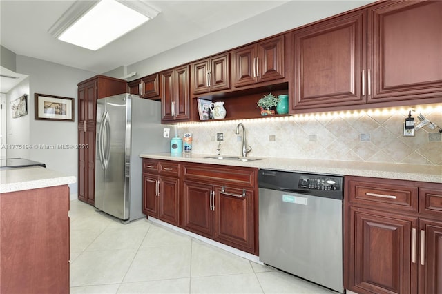 kitchen featuring backsplash, stainless steel appliances, light tile patterned floors, and a sink