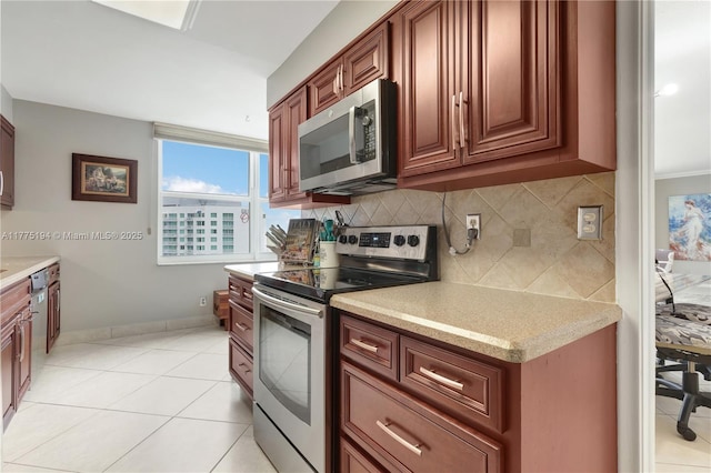 kitchen with backsplash, baseboards, stainless steel appliances, and light tile patterned flooring