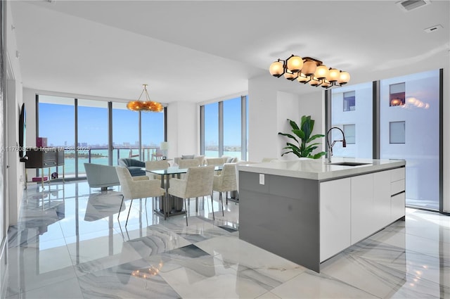 788 NE 23rd St Unit 1001, Miami, FL 33137 - kitchen with modern cabinets, a chandelier, floor to ceiling windows, white cabinetry, and a water view
