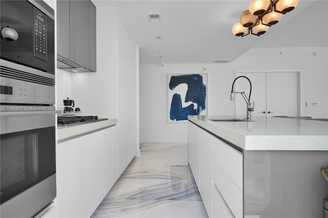 788 NE 23rd St Unit 1001, Miami, FL 33137 - kitchen with modern cabinets, appliances with stainless steel finishes, light marble finish floors, and an island with sink