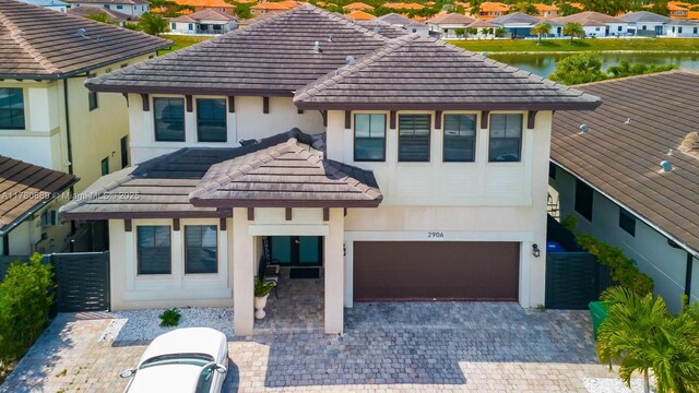 view of front facade featuring a tile roof, an attached garage, and stucco siding