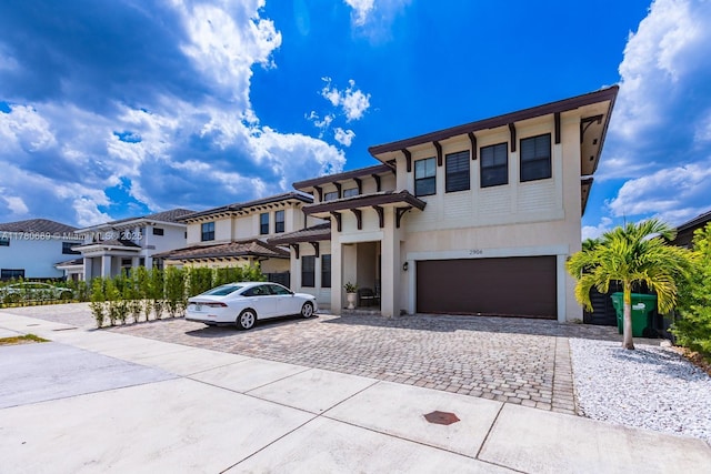 view of front of home with an attached garage, a residential view, driveway, and stucco siding