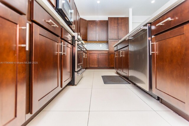 kitchen featuring dishwasher, light tile patterned floors, light countertops, and backsplash