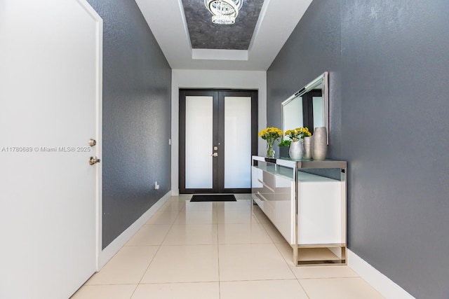 tiled foyer entrance with a textured wall and baseboards