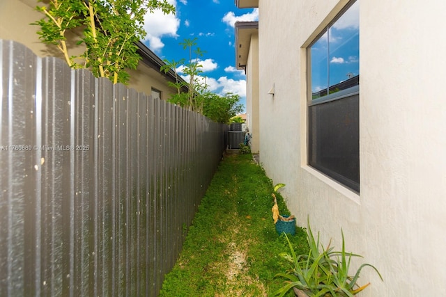 view of yard featuring central AC unit and fence
