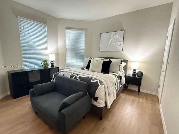bedroom with wood finished floors and baseboards