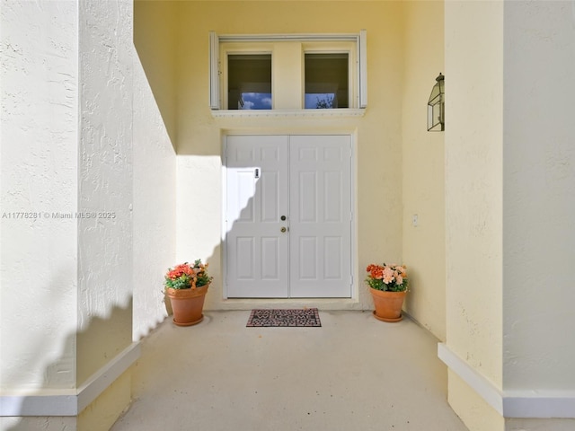 doorway to property featuring stucco siding