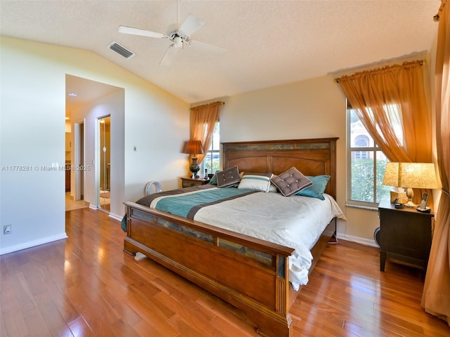 bedroom with visible vents, light wood-style flooring, multiple windows, and vaulted ceiling