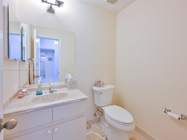 bathroom with visible vents, toilet, vanity, and baseboards
