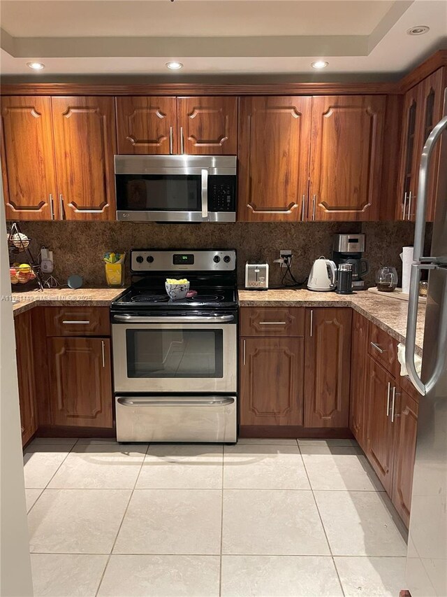 112 Royal Park Dr Unit 2G, Oakland Park, FL 33309 - kitchen with a raised ceiling, recessed lighting, stainless steel appliances, decorative backsplash, and light tile patterned flooring