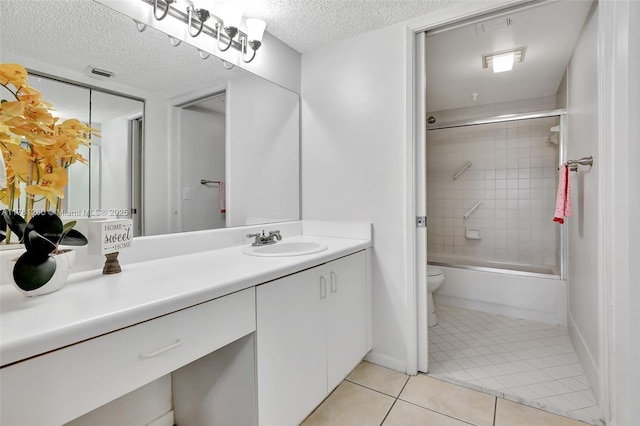 full bath featuring a textured ceiling, vanity, tile patterned flooring, toilet, and combined bath / shower with glass door