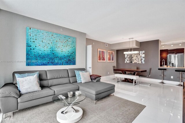 325 S Biscayne Blvd Unit 2519, Miami, FL 33131 - living room featuring tile patterned floors, baseboards, an inviting chandelier, and track lighting