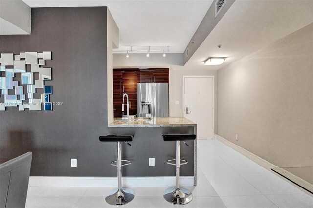 325 S Biscayne Blvd Unit 2519, Miami, FL 33131 - bar featuring baseboards, rail lighting, stainless steel refrigerator with ice dispenser, visible vents, and a sink