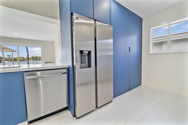 5020 SW 92nd Ave, Miami, FL 33165 - kitchen featuring appliances with stainless steel finishes, blue cabinetry, and light countertops