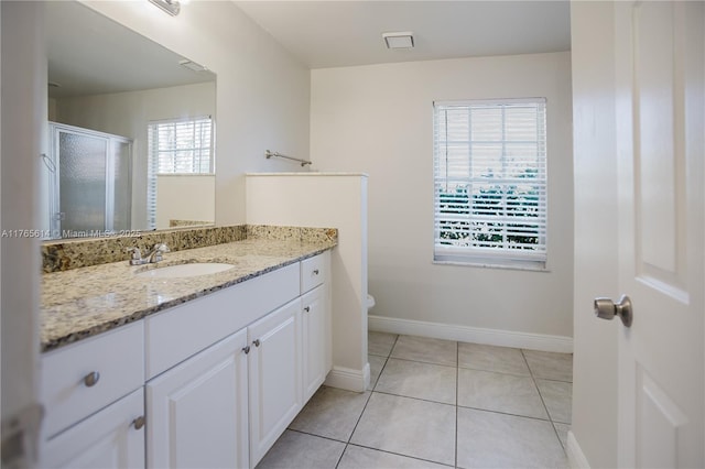full bathroom featuring a shower stall, vanity, toilet, tile patterned floors, and baseboards