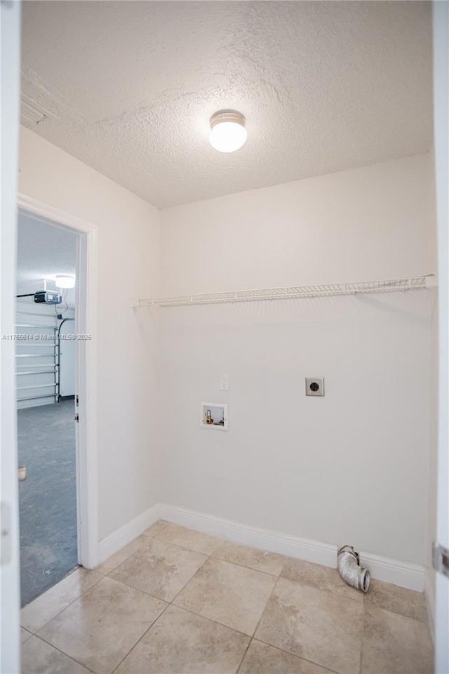 laundry room featuring laundry area, electric dryer hookup, a textured ceiling, washer hookup, and baseboards