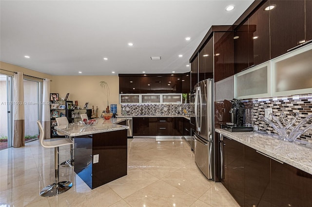 1094 Redwood St ., Unit Hollywood, FL 33019 - kitchen featuring dark brown cabinets, appliances with stainless steel finishes, a breakfast bar, and modern cabinets