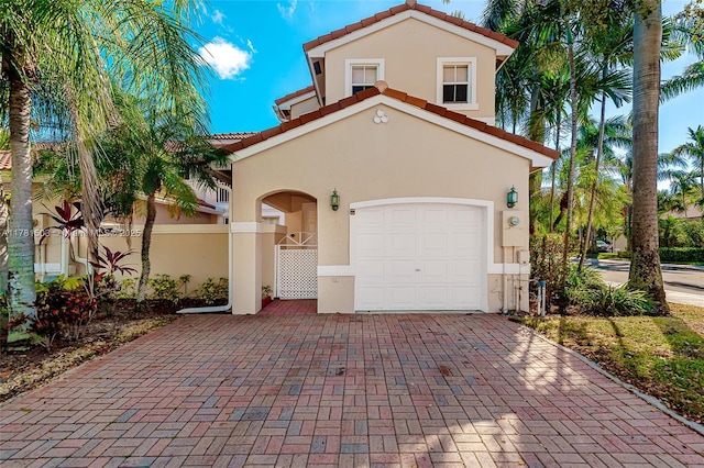 1094 Redwood St ., Unit Hollywood, FL 33019 - mediterranean / spanish-style home with an attached garage, a tile roof, stucco siding, a gate, and decorative driveway