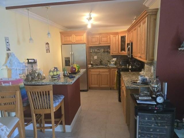 kitchen featuring glass insert cabinets, crown molding, a kitchen bar, stainless steel appliances, and a sink