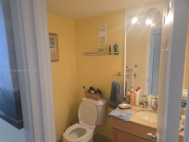 bathroom with visible vents, toilet, and vanity