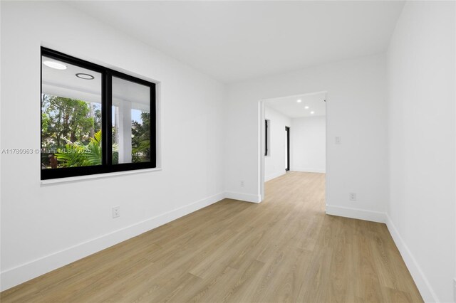 empty room featuring baseboards, recessed lighting, and light wood-style floors