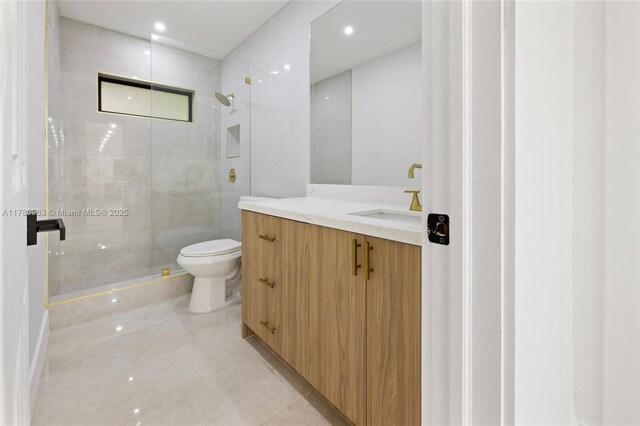 bathroom featuring a shower stall, vanity, and toilet