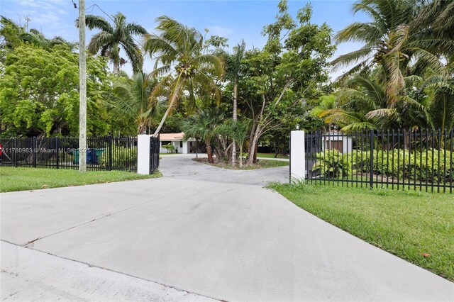 view of gate with a fenced front yard and a lawn