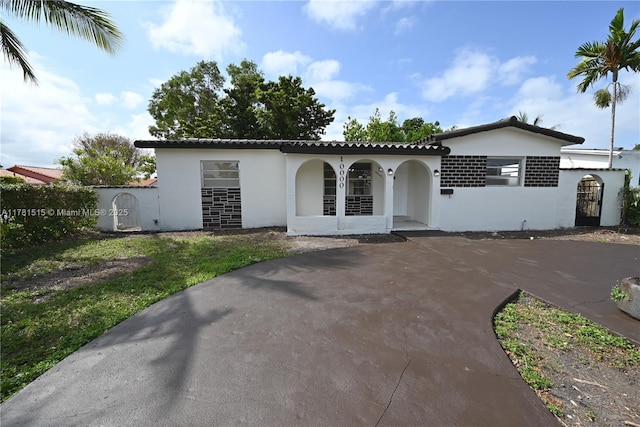 view of front of home with stucco siding, driveway, and covered porch