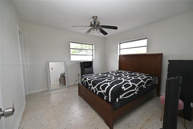 bedroom featuring light speckled floor, baseboards, and ceiling fan