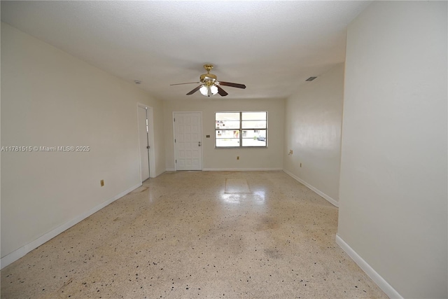 empty room featuring visible vents, a ceiling fan, and baseboards