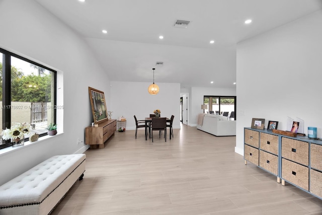 living room with visible vents, baseboards, recessed lighting, light wood-style flooring, and high vaulted ceiling