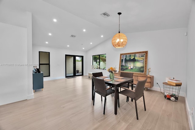 dining space with a notable chandelier, visible vents, vaulted ceiling, and light wood-style flooring