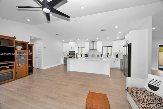 living room featuring light wood-style floors, a ceiling fan, recessed lighting, and lofted ceiling