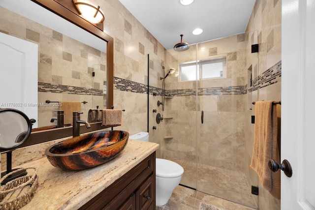 bathroom with vanity, recessed lighting, toilet, tile walls, and a stall shower