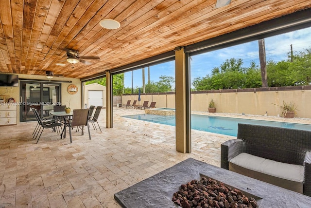 view of pool with a patio, an outdoor structure, outdoor dining area, a fenced backyard, and ceiling fan