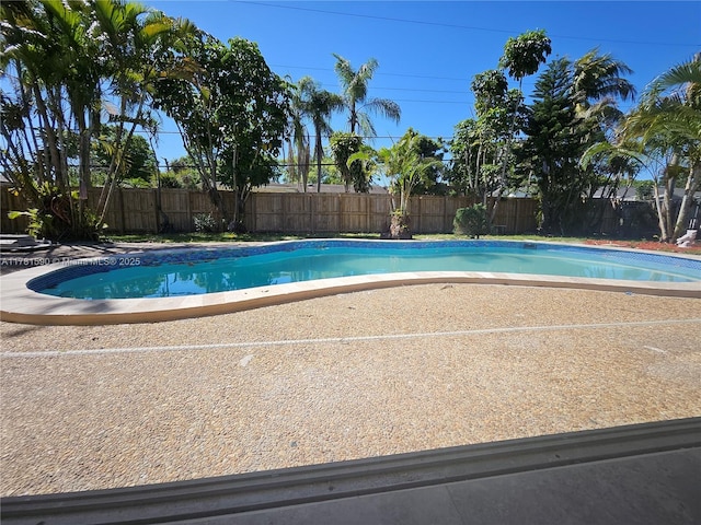 view of swimming pool featuring a fenced in pool, a fenced backyard, and a patio area