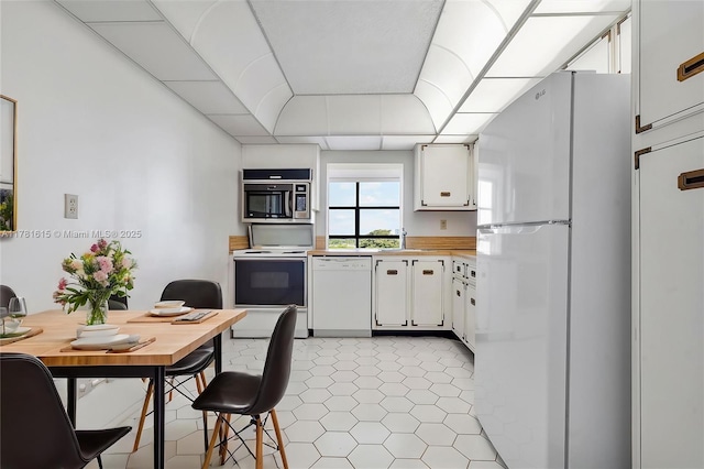 600 Parkview Dr Unit 625, Hallandale Beach, FL 33009 - kitchen featuring white appliances, white cabinets, light tile patterned flooring, a sink, and light countertops