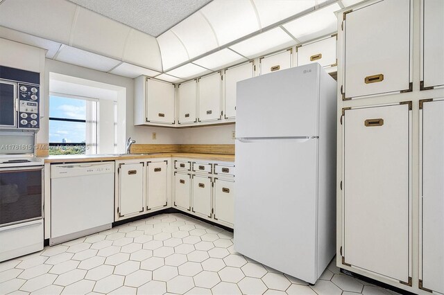 600 Parkview Dr Unit 625, Hallandale Beach, FL 33009 - kitchen with freestanding refrigerator, white cabinets, visible vents, electric panel, and light countertops