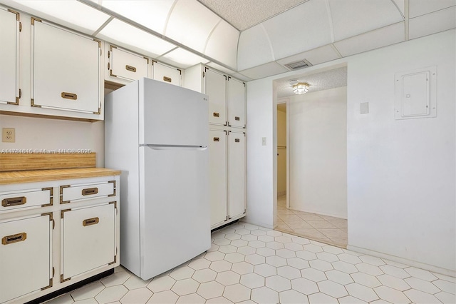 600 Parkview Dr Unit 625, Hallandale Beach, FL 33009 - kitchen featuring electric panel, light countertops, freestanding refrigerator, white cabinets, and visible vents