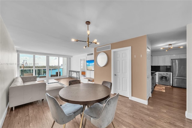 6770 Indian Creek Dr Unit 9G, Miami Beach, FL 33141 - dining room featuring washer / dryer, a chandelier, and light wood-style floors