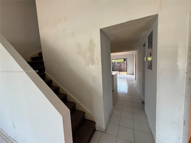 stairway featuring tile patterned floors and baseboards