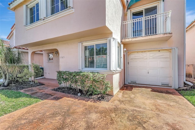 1163 SE 6th Ct, Dania Beach, FL 33004 - view of exterior entry with an attached garage and stucco siding