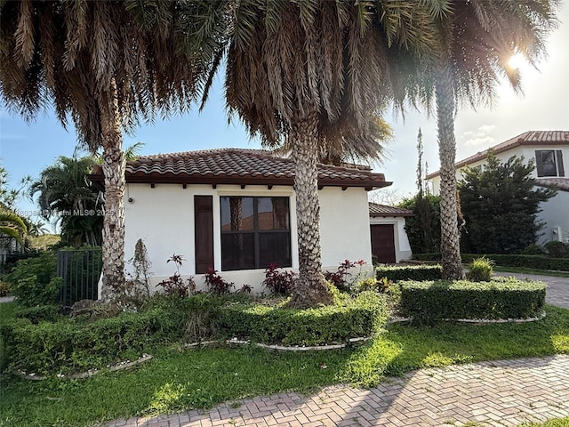view of home's exterior with a tile roof and stucco siding