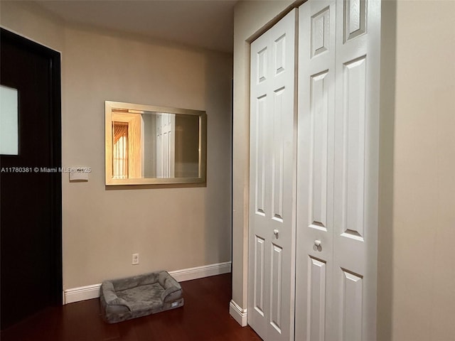 corridor featuring dark wood-style flooring and baseboards