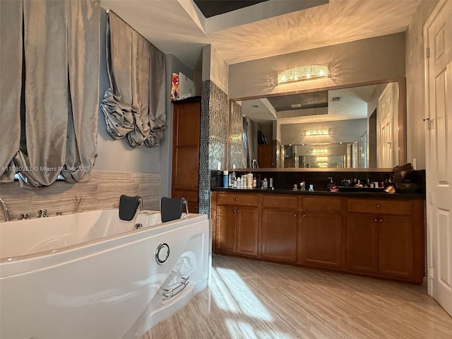 full bathroom featuring a garden tub, double vanity, a sink, and wood finished floors