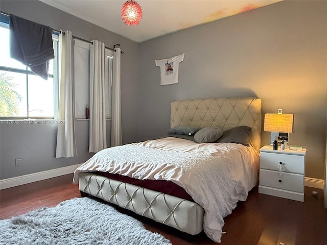 bedroom with wood finished floors and baseboards