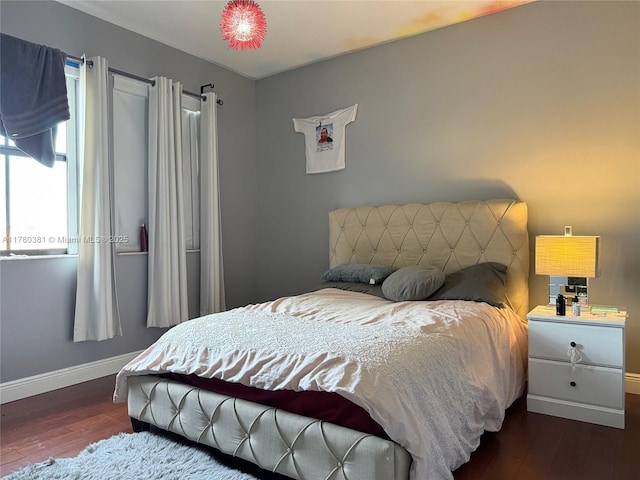 bedroom with baseboards and wood finished floors