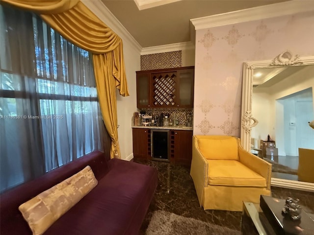 sitting room featuring wine cooler, a bar, crown molding, and wallpapered walls