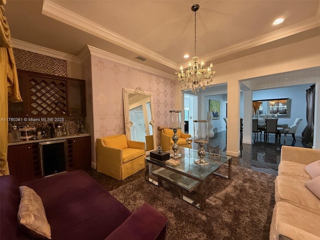 living area featuring a tray ceiling, ornamental molding, visible vents, a chandelier, and wallpapered walls