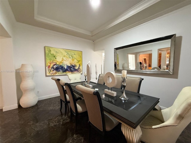 dining space featuring a raised ceiling, crown molding, and baseboards